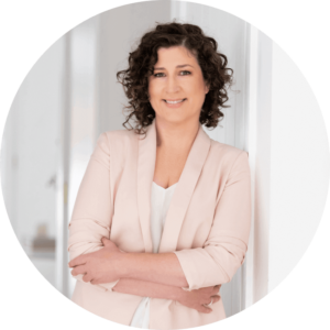 Headshot of Marnie Cooper Mediator, Conflict Coach and Separation Strategist. She is wearing a pink jacket and is leaning against a wall.