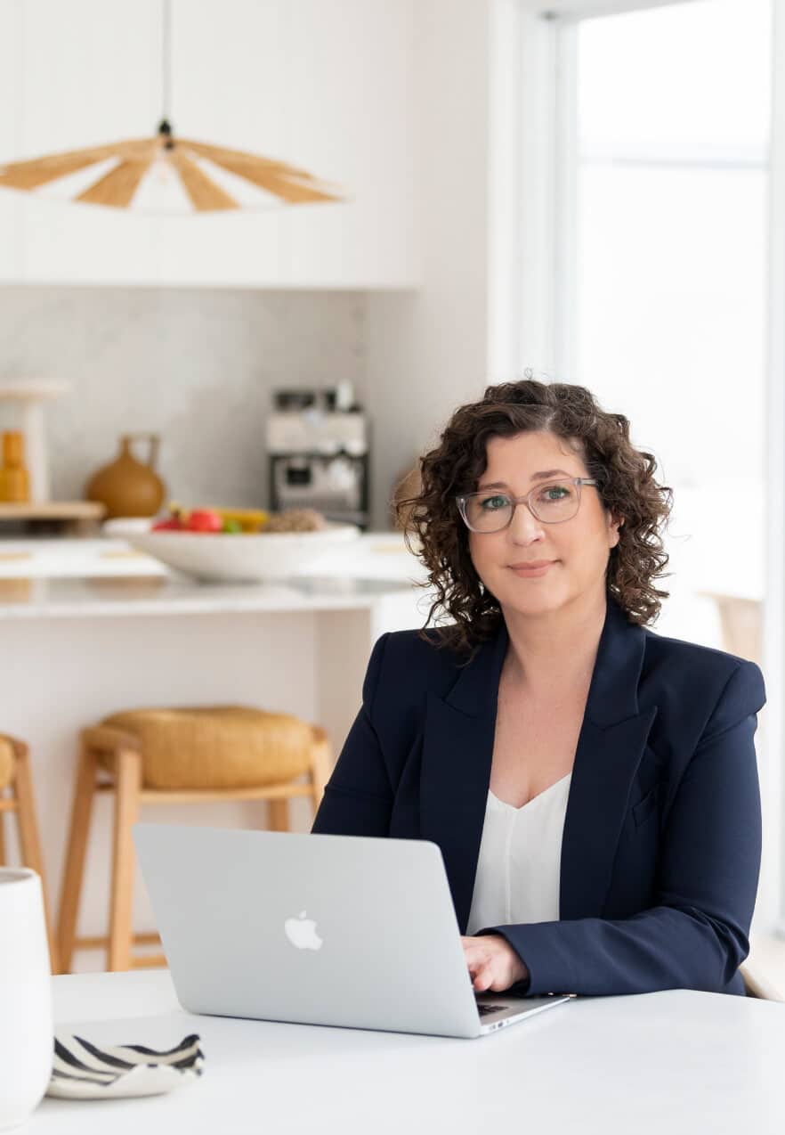 Marnie Cooper sitting at a table with her laptop.